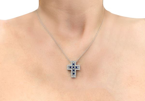 Damiani - Pendant with cross in 18kt gold, round brilliant cut diamond 0.55 and carrè sapphires 0.30