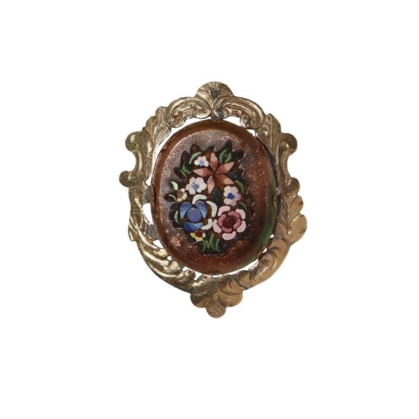 Low-title gold brooch with commissions of semi-precious stones in mosaic with floral motifs.