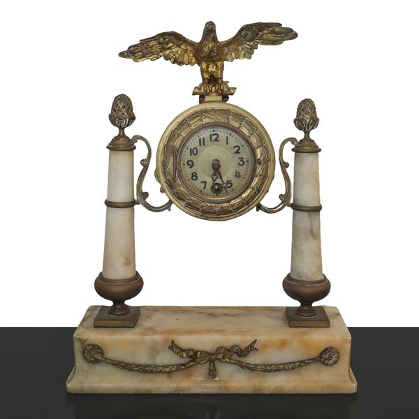 Orologio in metallo dorato sormontato da un aquila e colonne in alabastro 