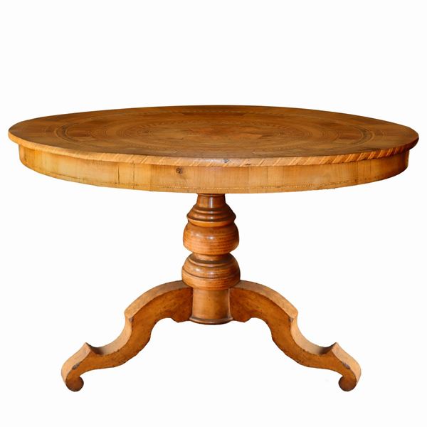 Antico tavolo rotondo Sorrentino, in legno di noce, intarsiato in legni vari a contrasto, a motivi circolari concentrici. Figura centrale raffigurante San Giorgio e il Drago. Balza sottopiano, piede a quattro razze interamente intarsiato.