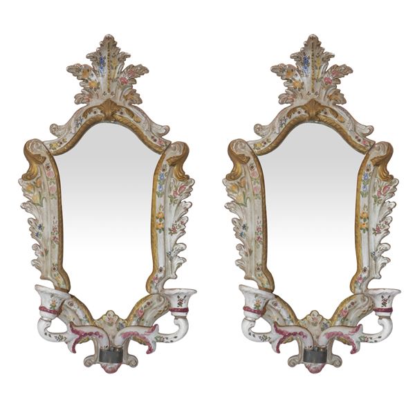 Pair of polychrome ceramic mirrors with floral and grotesque decorations at the base