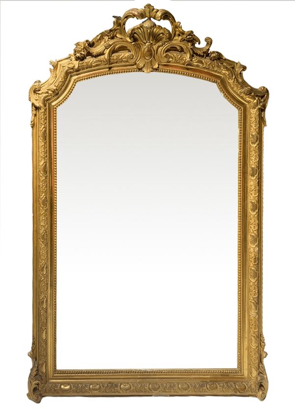 Mirror in gilded wood leafy topped by cymatium,. 155x110 cm