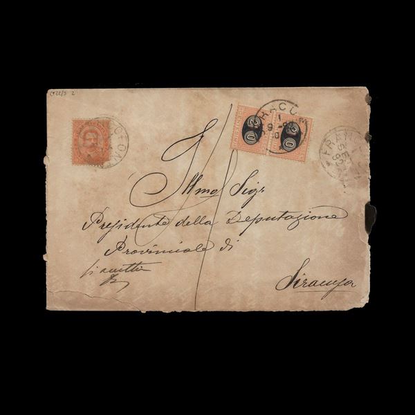 Busta spedita da Francofonte (SR) l'1/9/1892 per Siracusa, affrancata con 20 c. Umberto prima emissione (difettoso all'origine) e tassata in arrivo per 40 centesimi con coppia di segnatasse soprastampati tipo "Mascherine".