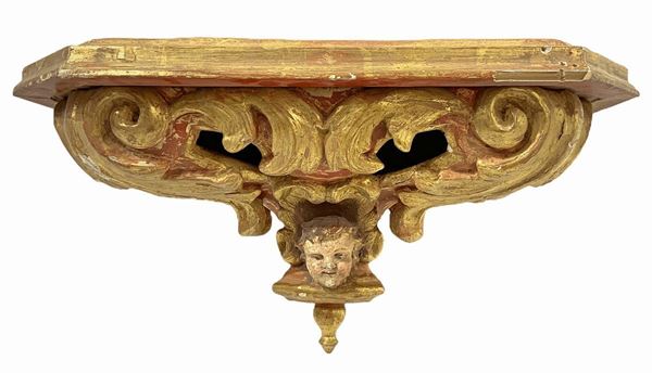 Mensola in legno dorato a foglia e laccata in rosso pompeiano, XVIII secolo. H cm 26x45x25. Mancanze di colore