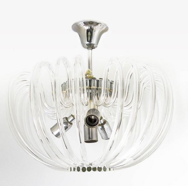 Bakalowicz & Sone, anni '70. Lampadario in vetro di Murano con elementi in vetro di forma curva. Struttura in metallo cromato. 


H cm 30x40
