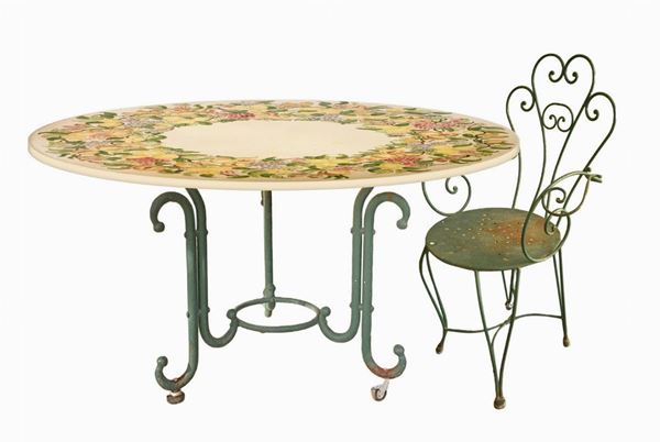 Round table in lava stone and n. 4 chairs. Table decorated with polychrome ceramic with lemons and. 20th century, pomegranates on the floor. Four iron chairs ...