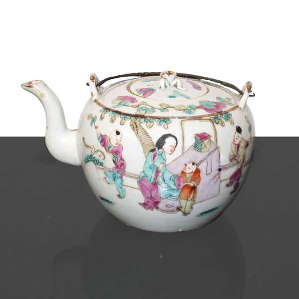 Chinese porcelain teapot with floral and character decorations.
