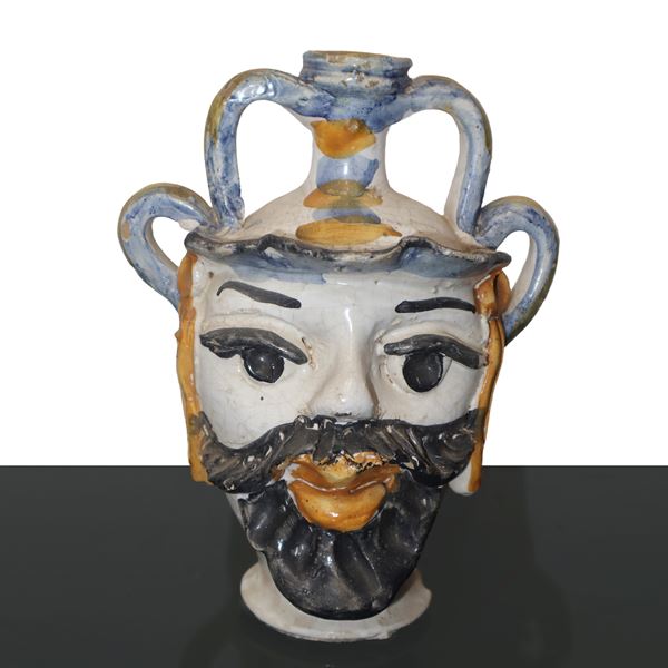 Head in polychrome majolica from Caltagirone, anthropomorphic and with handles.