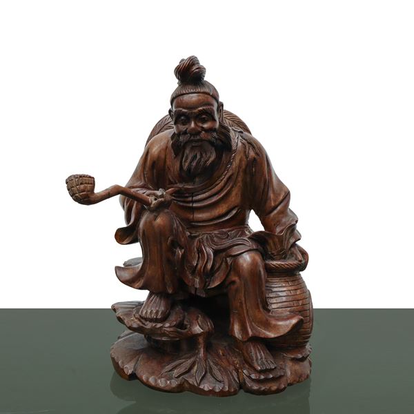 Carved wooden sculpture of a man with a pipe