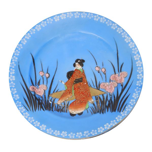 Japanese blue glazed ceramic plate with a depiction of a geisha in a flower field