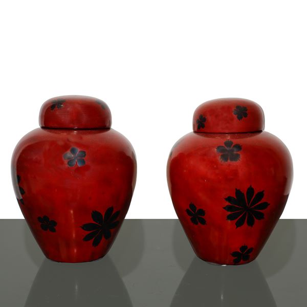 Pair of oriental vases with red lacquered lids and black floral decorations
