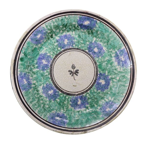 Piatto in maiolica di Caltagirone spugnato verde e azzurro a motivi floreali, fiore in manganese al centro