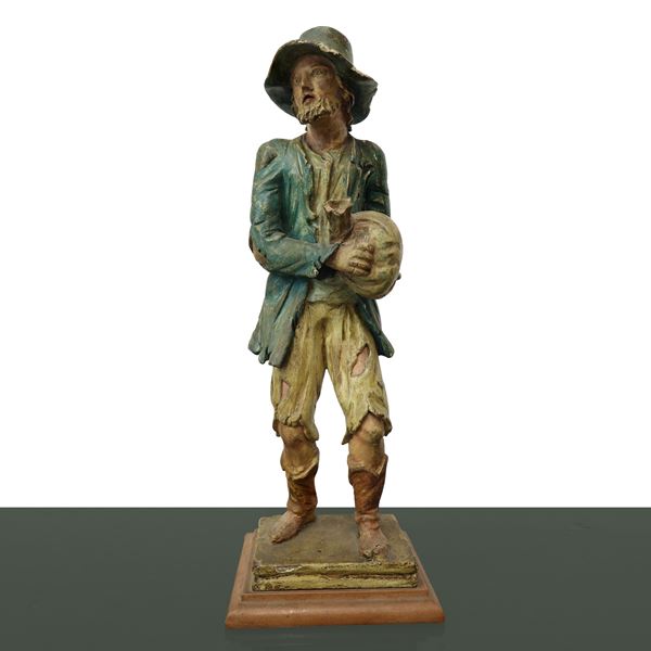 Man with bag in hand in polychrome wood