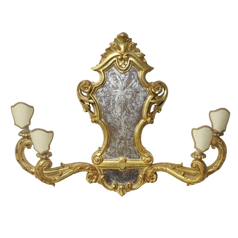 Fregio con bracci e candele in legno dorato, al centro foglia d'argento bulinata a motivi floreal...