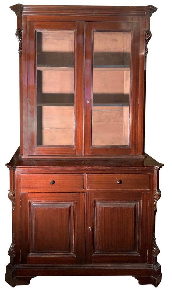 Credenza in legno di mogano. Sicilia, XIX secolo. Doppio corpo. Parte superiore con sportelli a vetri. Parte inferiore due cassetti, due sportelli. ... 