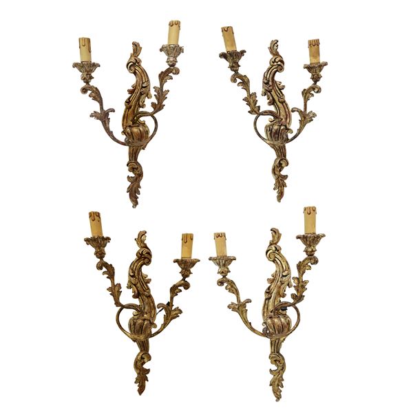 Group of four two-light sconces in gilded wood