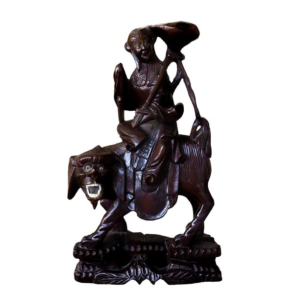 Asian wooden figurine man riding mythological animal