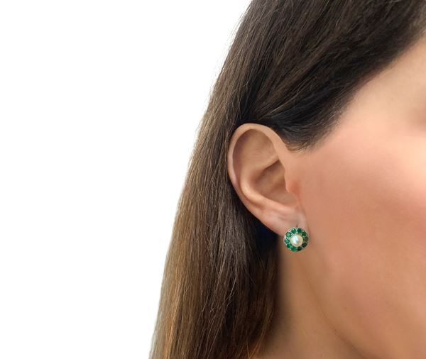 White gold earrings with central pearl and surrounding emeralds