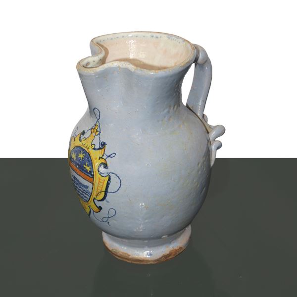 Majolica jug, glazed in blue and central coat of arms.