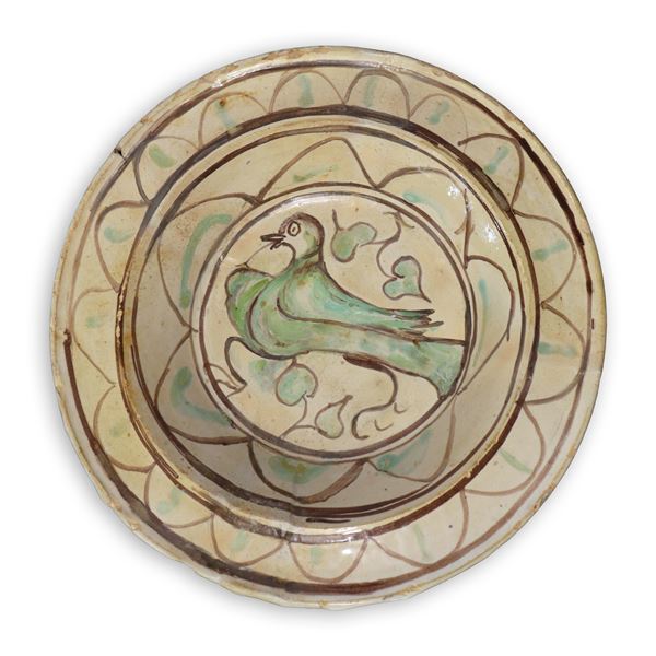 Polychrome majolica plate with depiction of a bird in the centre.