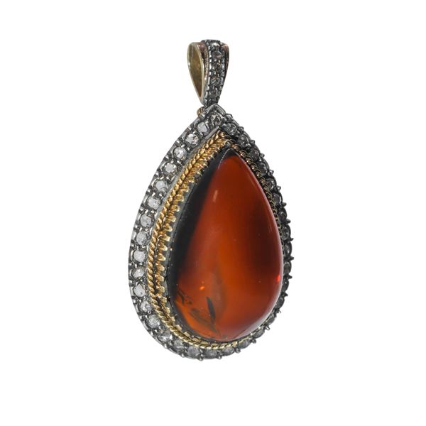 Red and white gold pendant with beautiful workmanship surrounding Baltic amber and diamonds