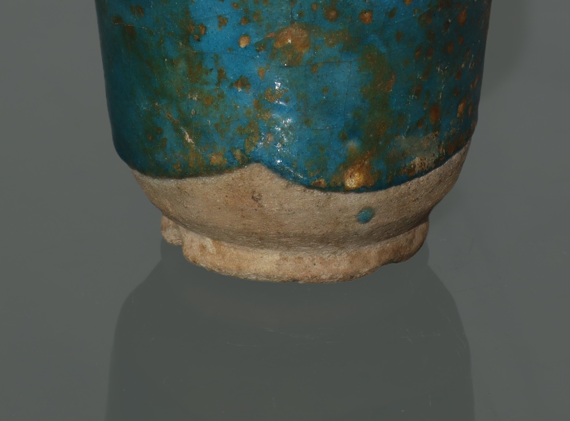 Piccolo albarello in ceramica persiana, con smalto verde e tracce di iridescenza dorata