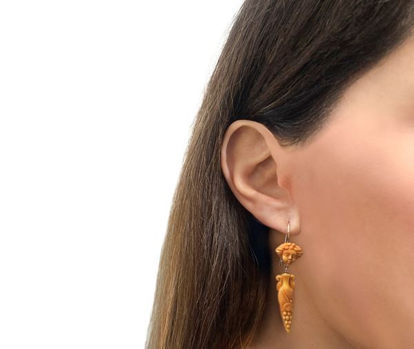 Earrings in low title yellow gold and corals, with a depiction of Bacchus