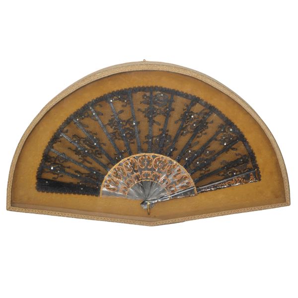 Fan with mother-of-pearl-like ribs and black lace, in fan rack