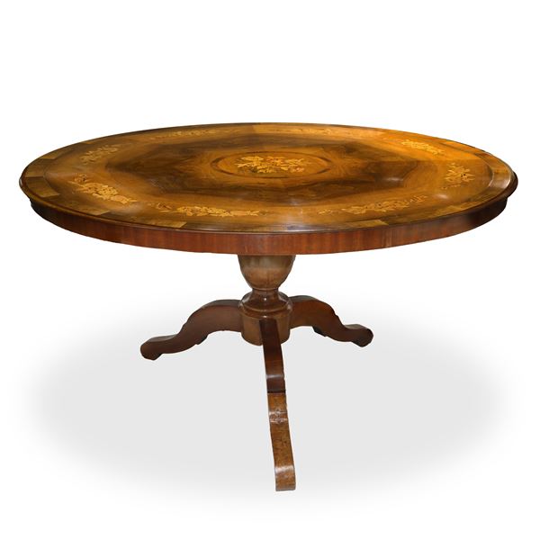 Round table with floral inlays on the colored top in various woods.