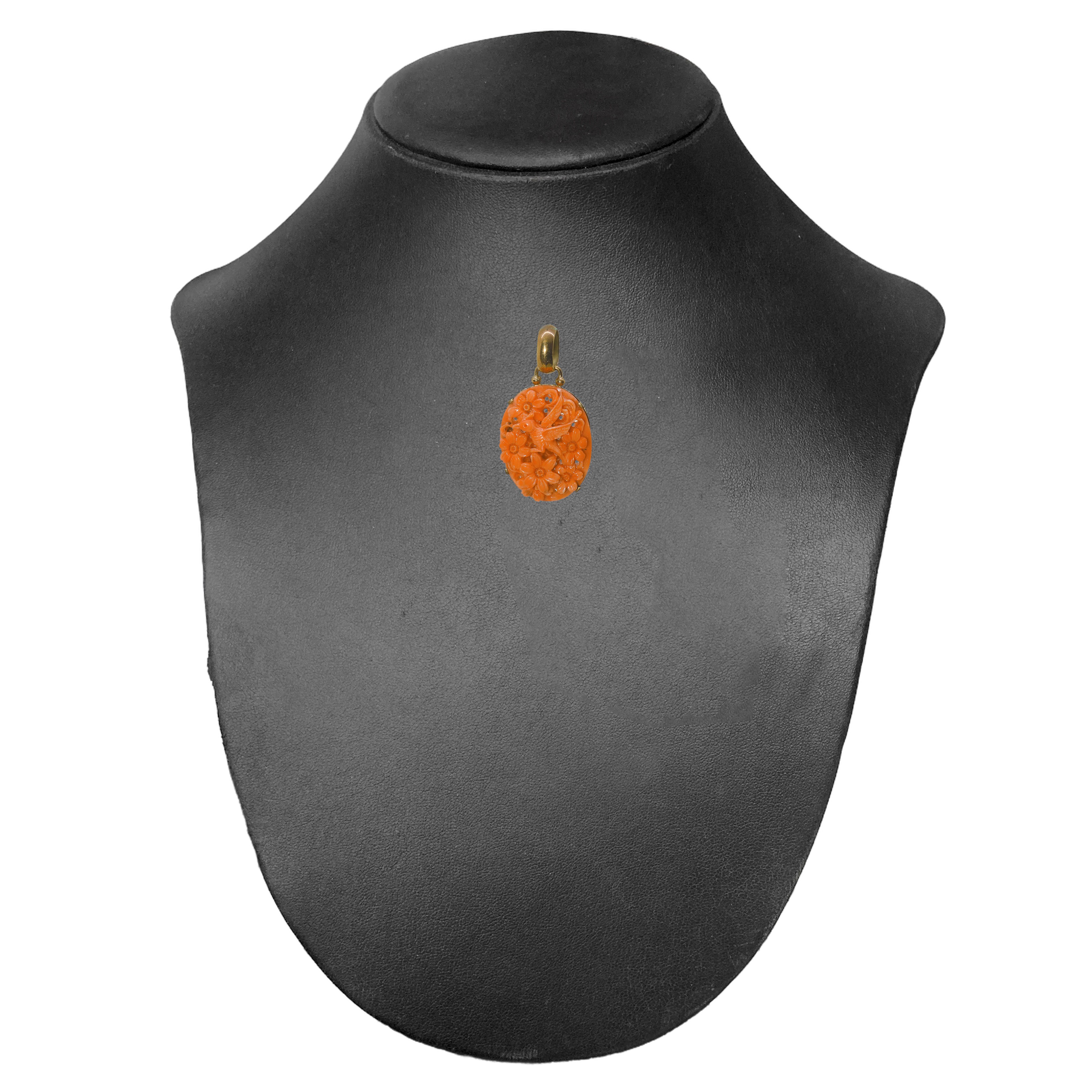 Ciondolo in oro a basso titolo e corallo rosa intarsiato con motivi floreali e uccello