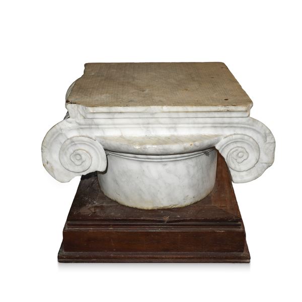 White marble capital with wooden base