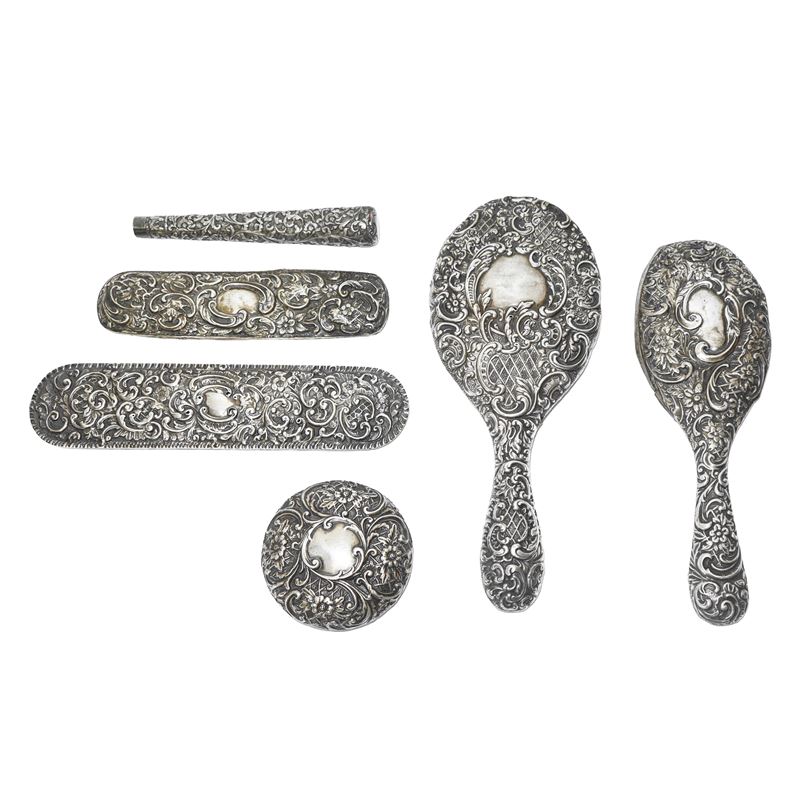 Gruppo composto da n°6 rivestimenti per oggetti da toletta in argento lavorato e sbalzato a mano