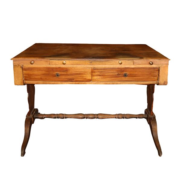 Walnut wood desk with drawer under the top and drawers on the sides, lyre-shaped feet connected by a spool footrest