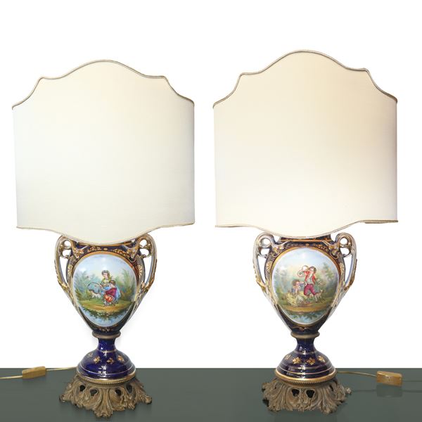 Coppia di lumi con vasi in porcellana dipinti con scene di genere e motivi floreali in porcellana blu stile Sevres