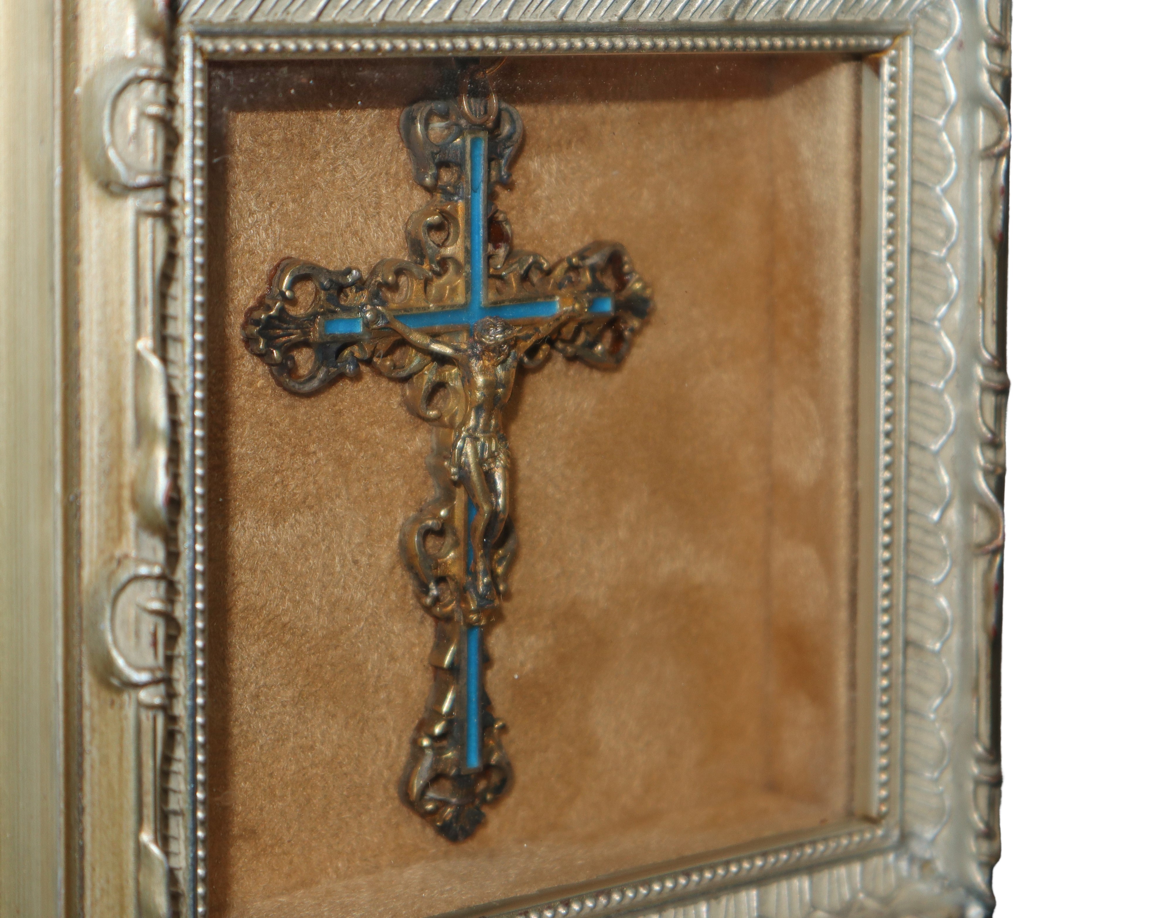 Crocifisso in metallo argentato e dorato con smalti, in teca.