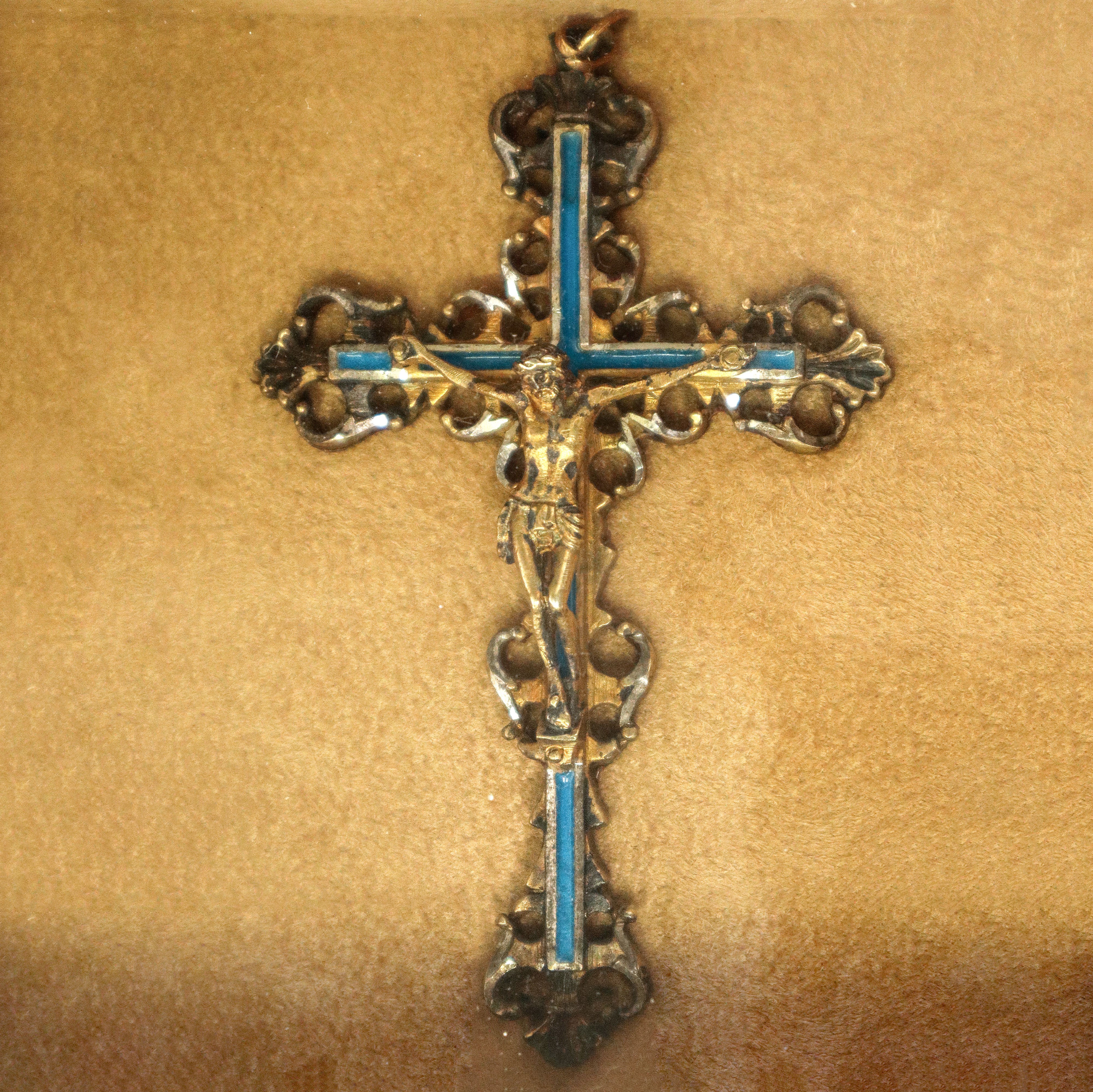 Crocifisso in metallo argentato e dorato con smalti, in teca.