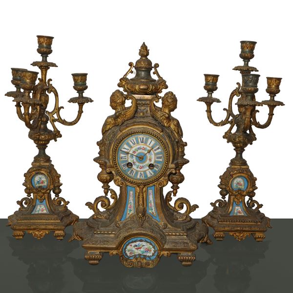 Trittico in bronzo dorato composto da orologio e due candelabri