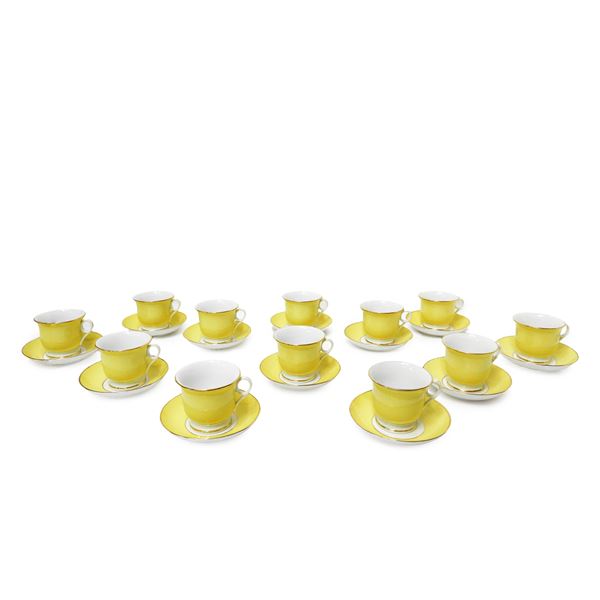 Twelve yellow porcelain teacups with gold rim and saucer