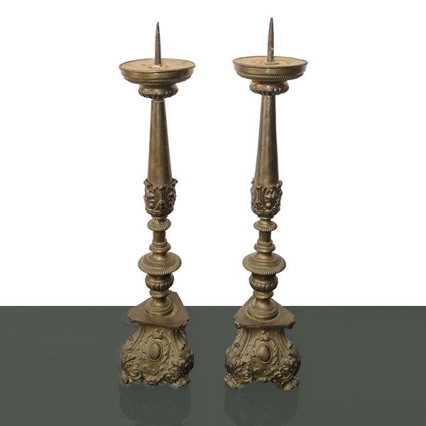 Pair of bronze candlesticks with triangular embossed base and decorations