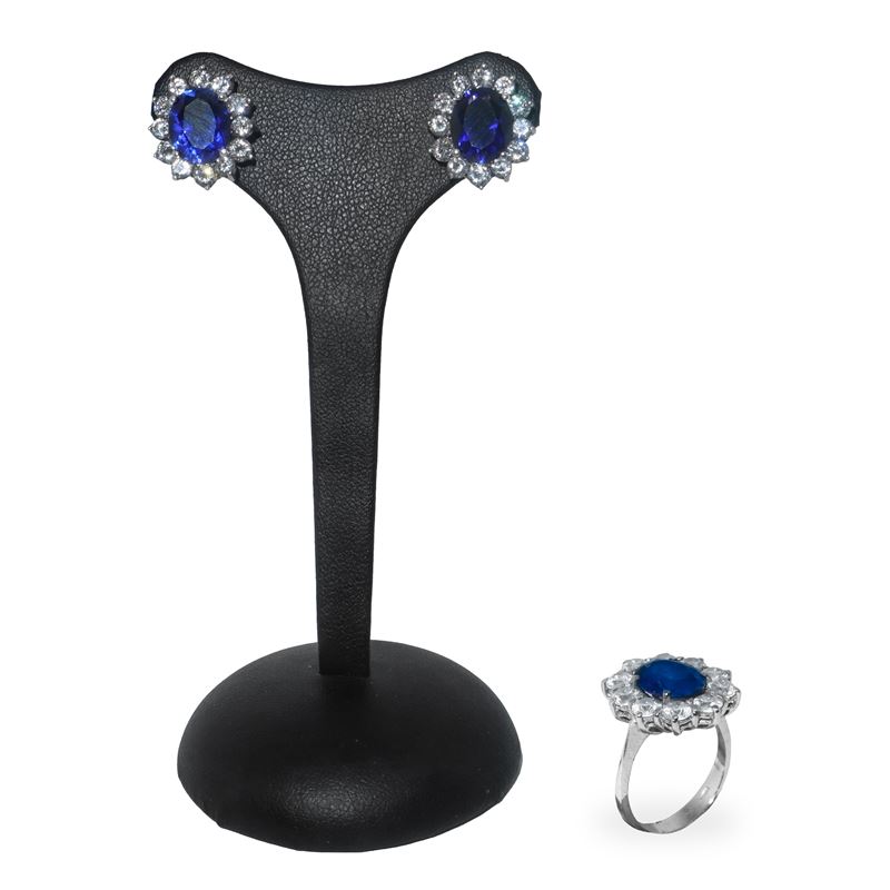 Parure in argento composta da anello e orecchini a forma di fiore con pietra blu centrale circond...