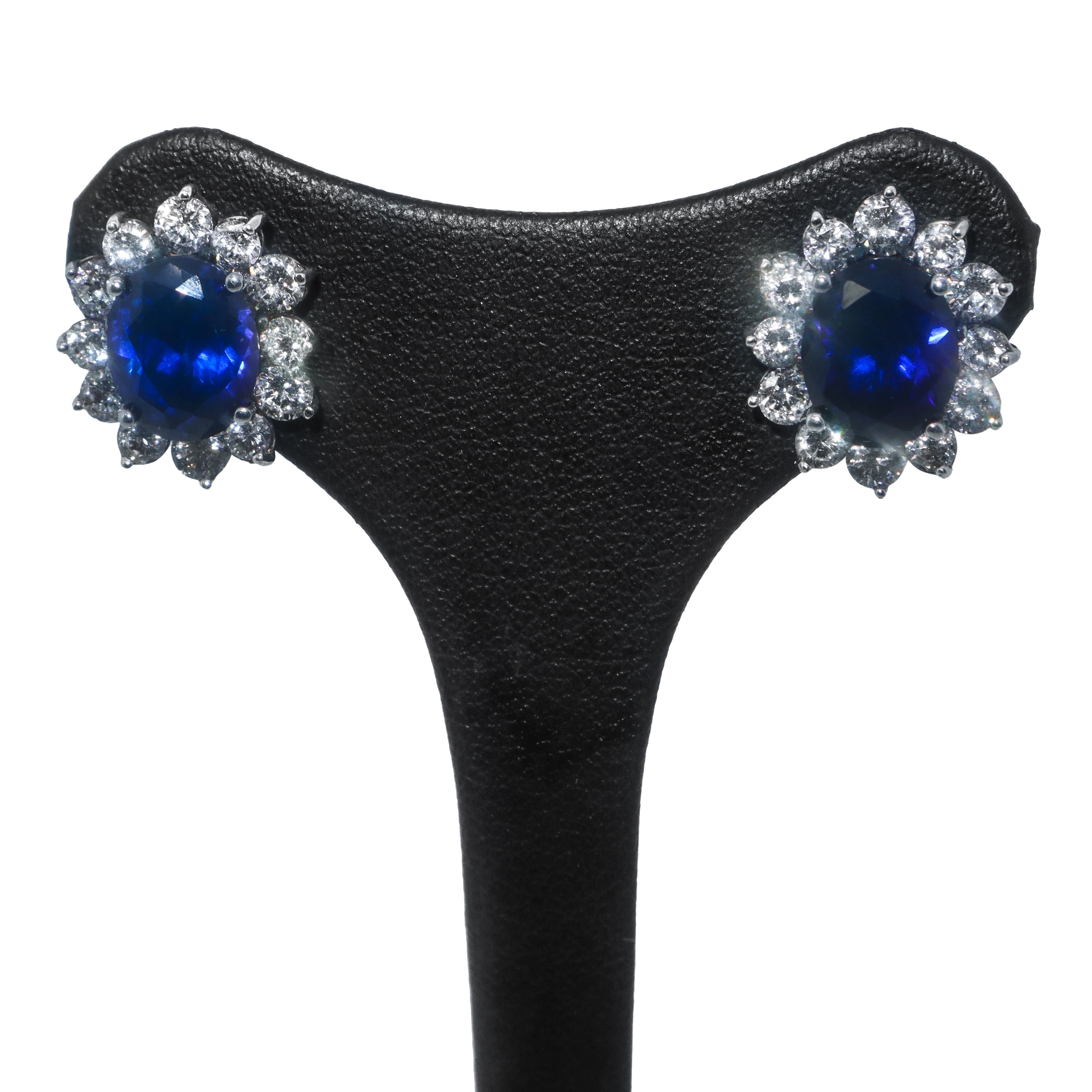 Parure in argento composta da anello e orecchini a forma di fiore con pietra blu centrale circond...