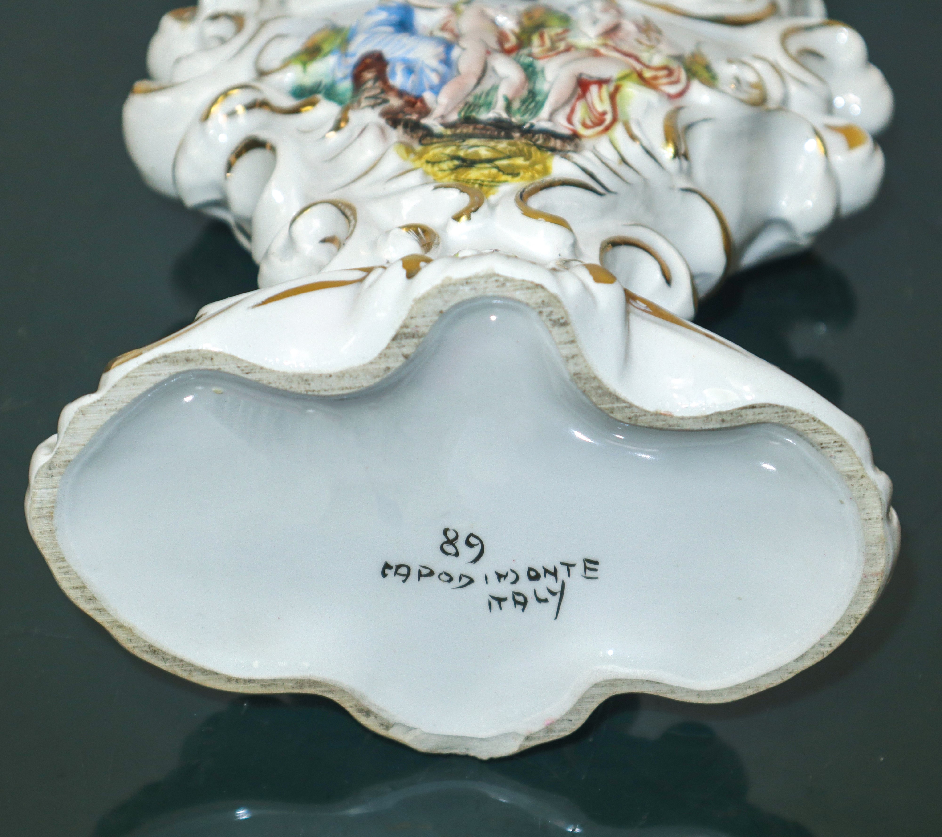 Capodimonte - Candelabro in maiolica policroma e dorata a due luci con personaggi mitologici