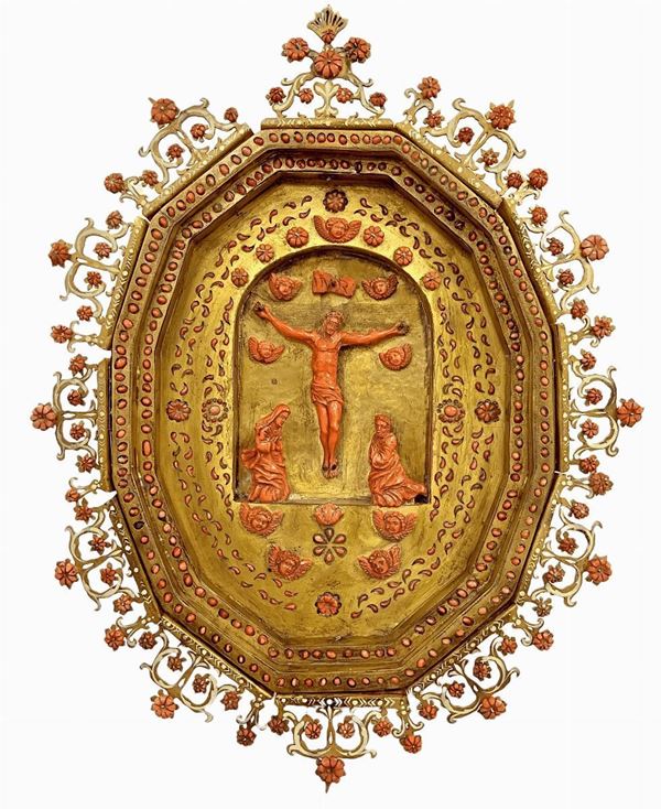 Antico capezzale in rame dorato e corallo, 
nello stile delle maestranze trapanesi del XVI/XVII secolo, raffigurante Cristo in croce, Madonna e San Giovanni, con zefiri a forma 
di dodecaedro equilatero, cm 39x 33. Corallo 275 gr circa
Quest'opera presenta varie affinità di stile con altre che sono state  prodotte a Trapani nei secoli XVI/XVII/XVIII. 
È caratterizzante la lavorazione del rame che, degradando verso l'interno fino ad una piccola edicola a lunetta centrale, dà un effetto di profo