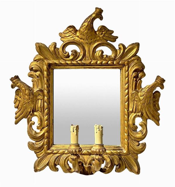 Specchiera in legno dorato a due candele, XVIII secolo. Scolpite ed intagliate con aquile coronate. Specchio coevo. Cm 56x54