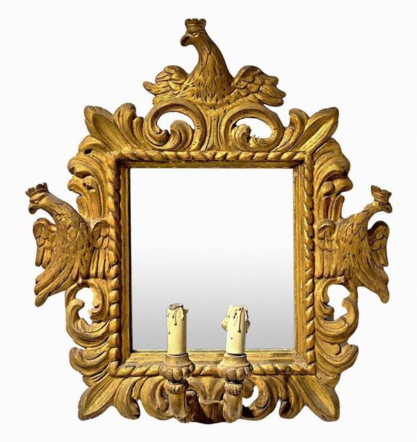 Specchiera in legno dorato a due candele, XVIII secolo. Scolpite ed intagliate con aquile coronate. Specchio coevo. Cm 56x54