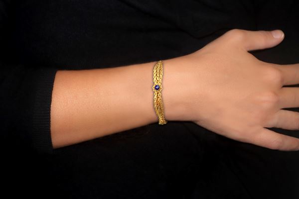 Bracciale semirigido in oro giallo 750 con chiusura di sicurezza e decoro flroeale con all'interno lapislazzuli