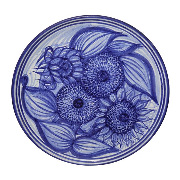 Piatto in maiolica nei toni del blu con raffigurazioni di girasoli