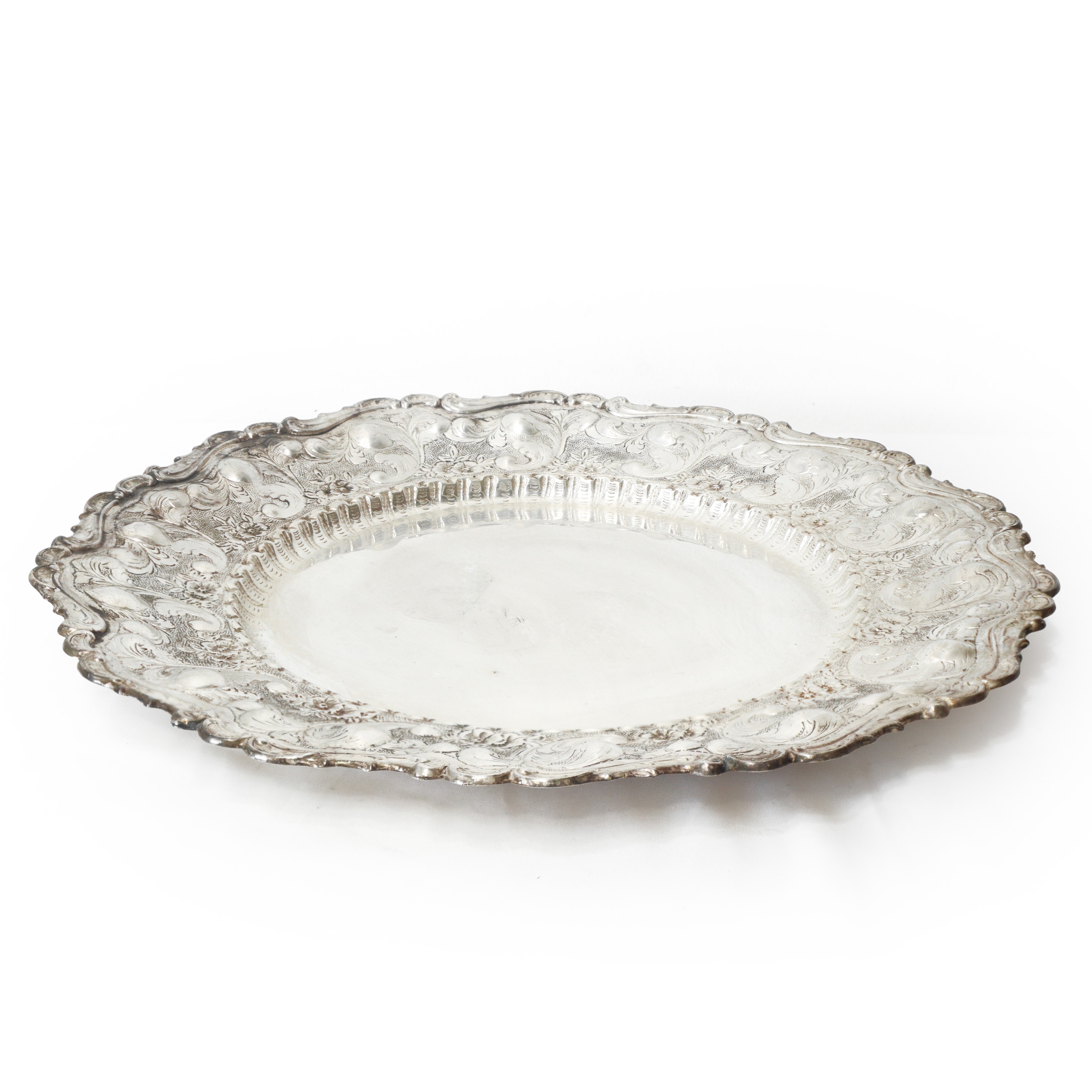 Piatto da centro in argento 800 sbalzato e inciso a motivi floreali con bordo smerlato