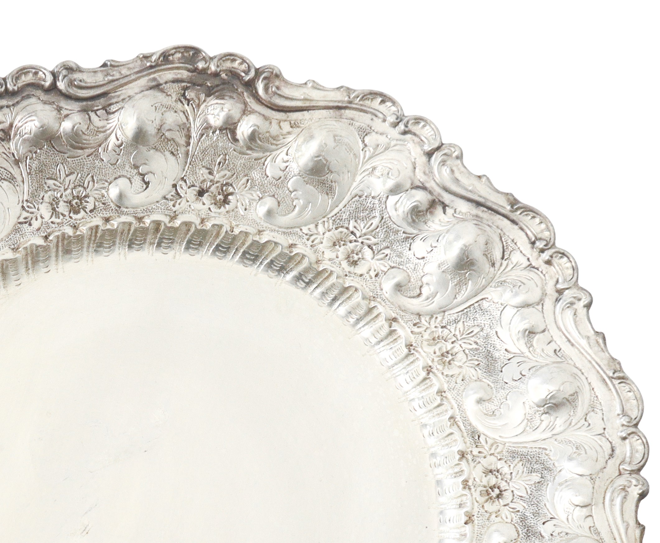 Piatto da centro in argento 800 sbalzato e inciso a motivi floreali con bordo smerlato