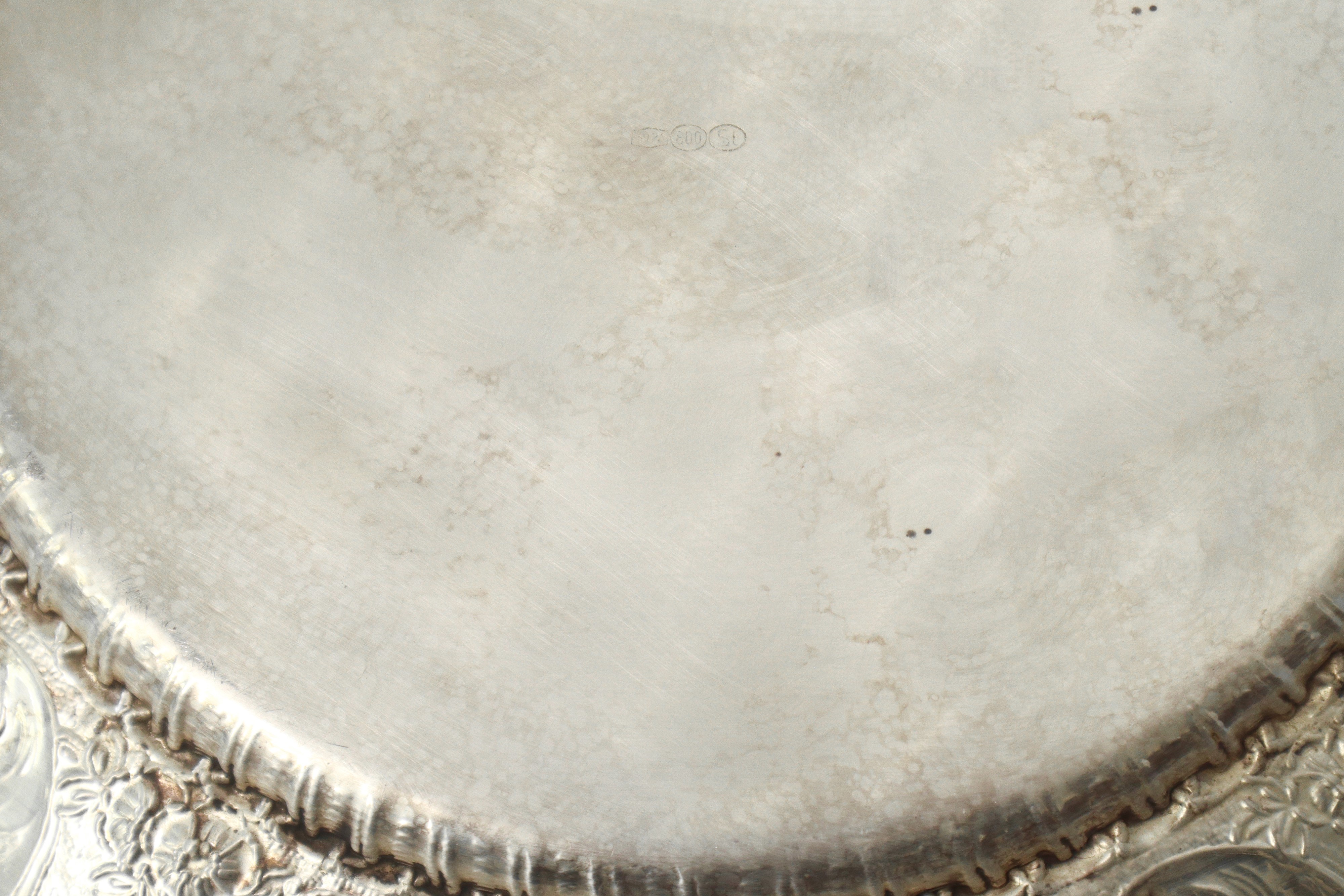 Piatto da centro in argento 800 sbalzato e inciso a motivi floreali con bordo smerlato